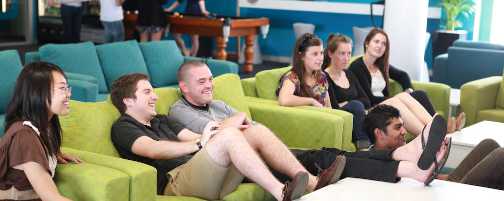 A group of ANU students on couches, all watching TV.