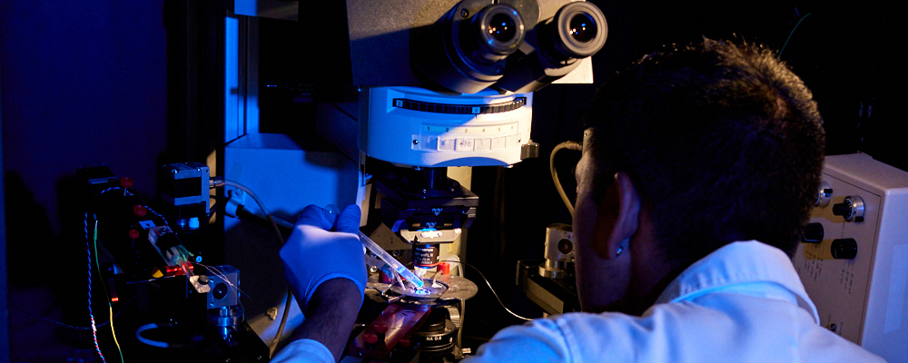A man examines samples under a microscope