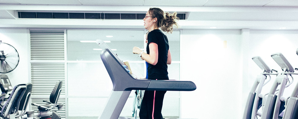 Two students run on treadmills in the ANU Fitness Centre. 