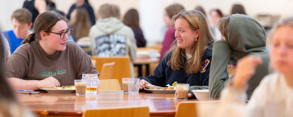Students eating and chatting in their residence dining hall