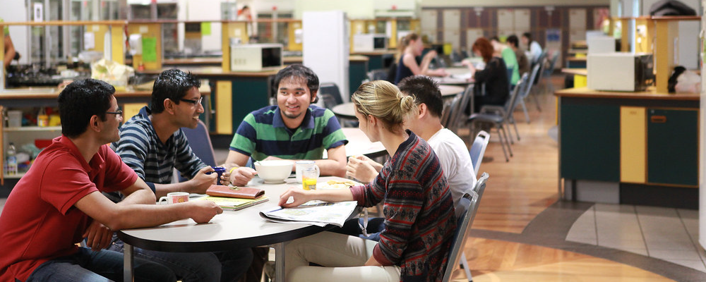 A group of ANU students around a table in a residence kitchen.