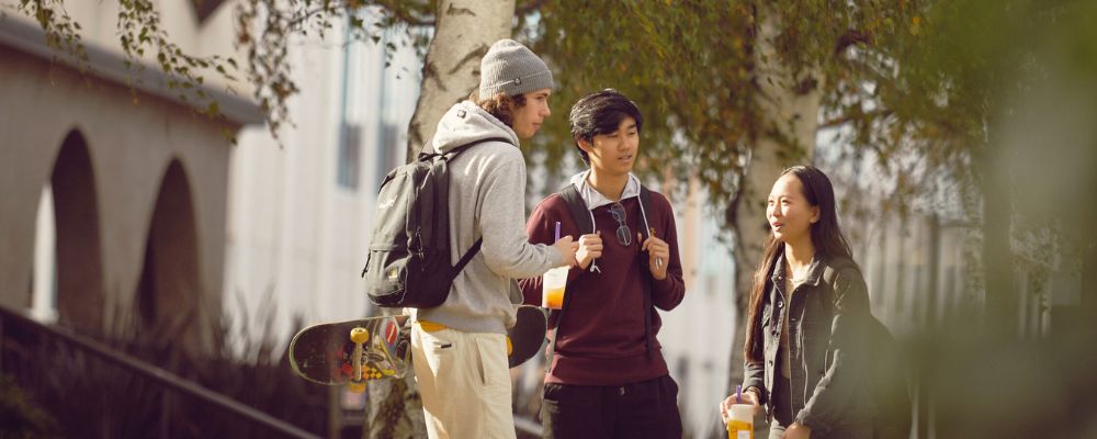 Three uni students talking to each other on campus at ANU.