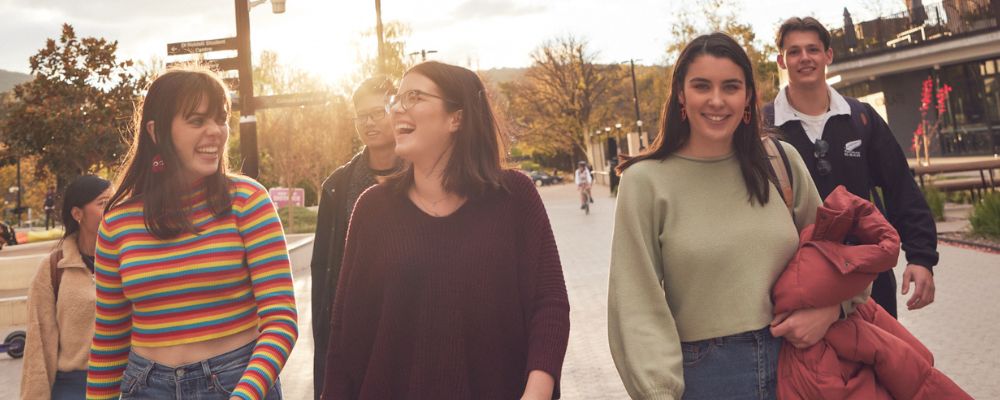 A group of ANU students enjoy their time together on campus as they walk along University Avenue.