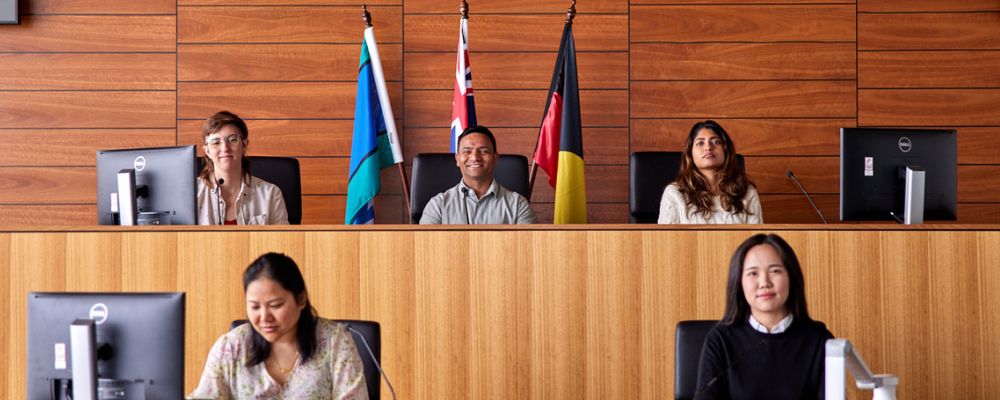 ANU students sitting together in the ANU College of Law Moot Court