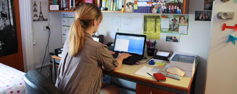 ANU female student working at her desk within on campus accommodation at ANU in Canberra.