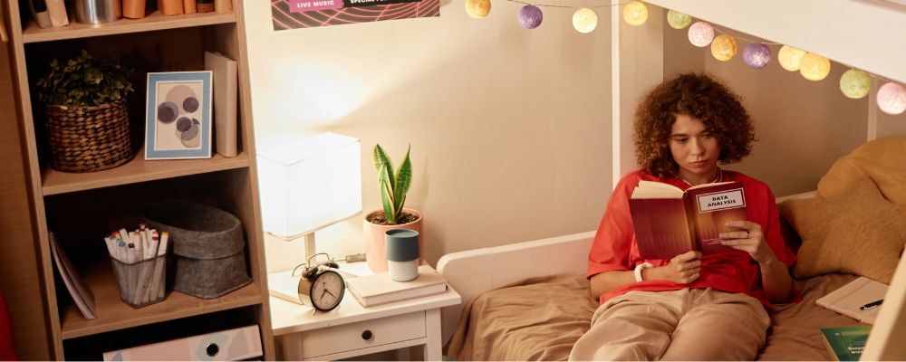 Female student sits within on campus accommodation.