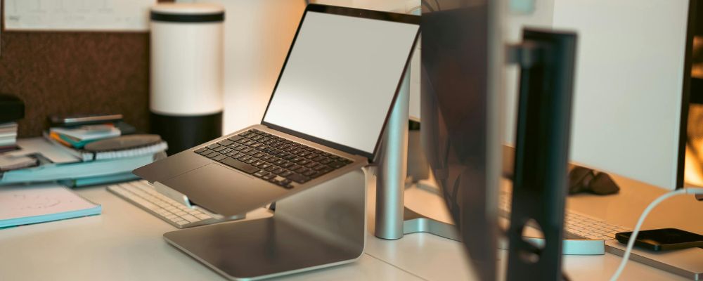A laptop stand sitting on a desk holding a laptop.