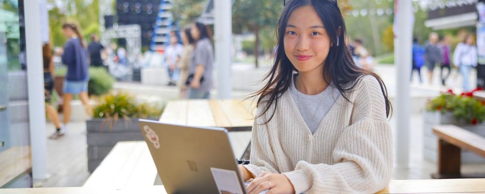 ANU student sitting outside at LAB café within the Kambri precinct at ANU in Canberra.