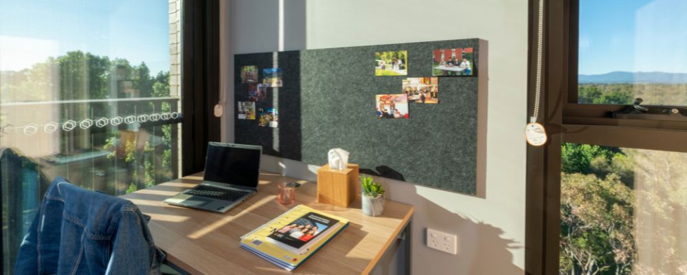 A desk set up facing a window within a student residence on campus at ANU.