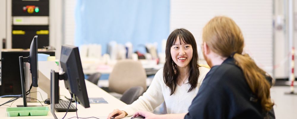 Two ANU postgraduate students sit in an ANU research facility in Canberra, Australia.