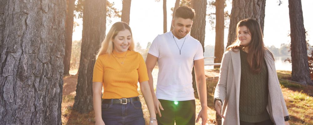 Three ANU students walk together at the National Arboretum.