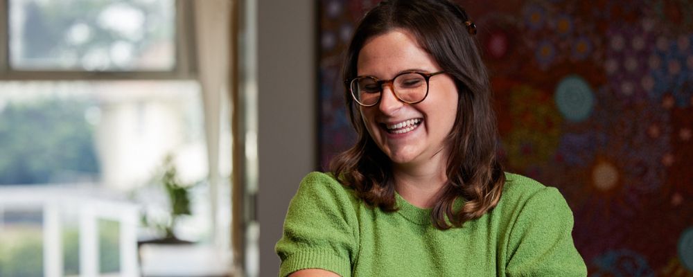 A female ANU student wearing a green top smiling.