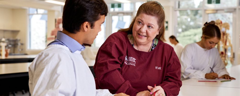 An ANU medical student and ANU tutor in an academic setting in discussion over coursework.
