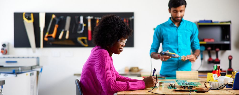 Two students studying postgraduate degrees at ANU work in a computing lab.E