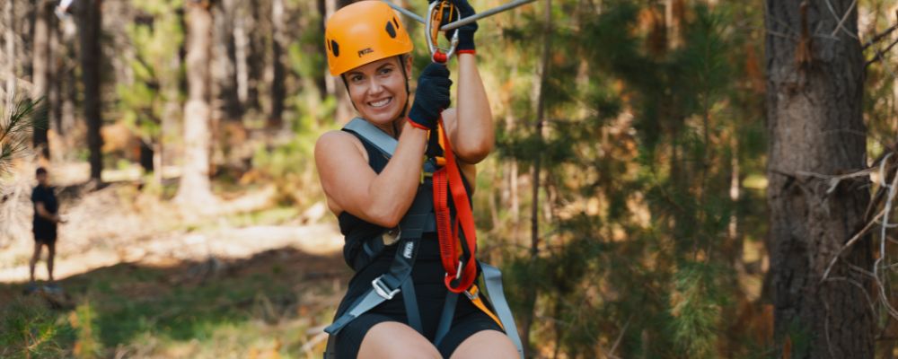 A woman goes down the zipline between the trees at Treetops Adventure in the Tidbinbilla Nature Reserve in Canberra.