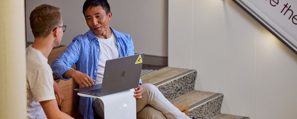 Two postgraduate students at ANU sitting at a study space on campus together.