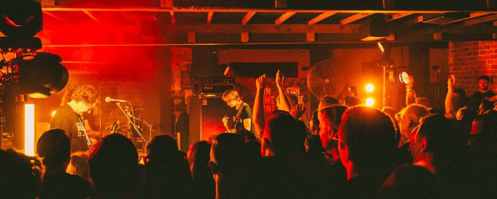 The interior of the Fun Time Pony bar and music venue in Canberra hosting a live band with a full crowd watching and dancing.