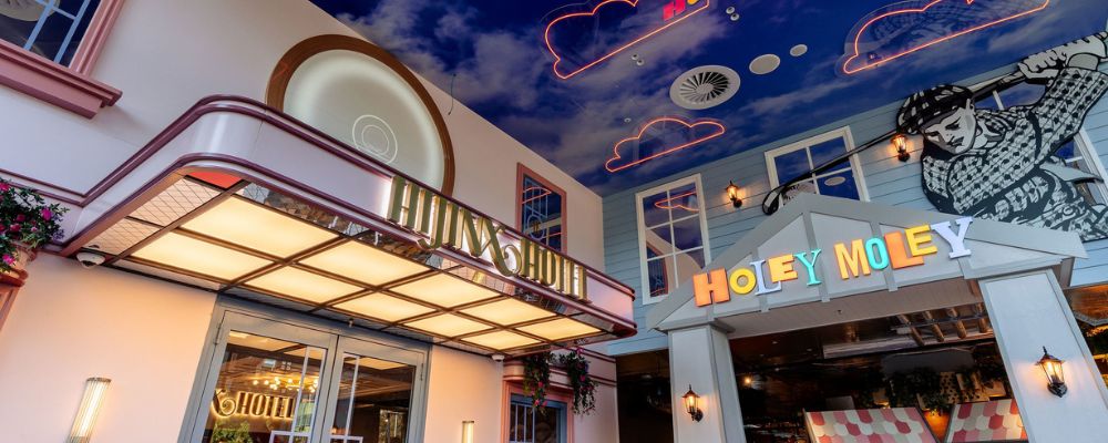 The Holey Moley mini golf venue in Canberra with a bright hotel-themed entrance, neon ceiling lights and colourful signage.