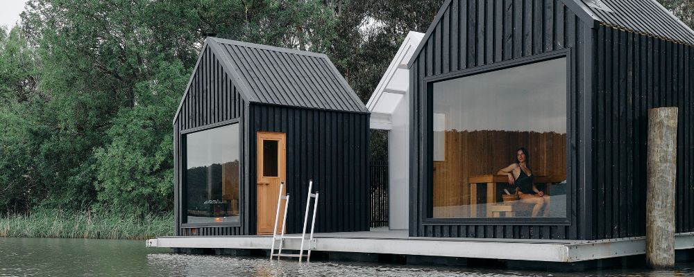 Two floating saunas on Lake Burley Griffin in Canberra surrounded by water and greenery.