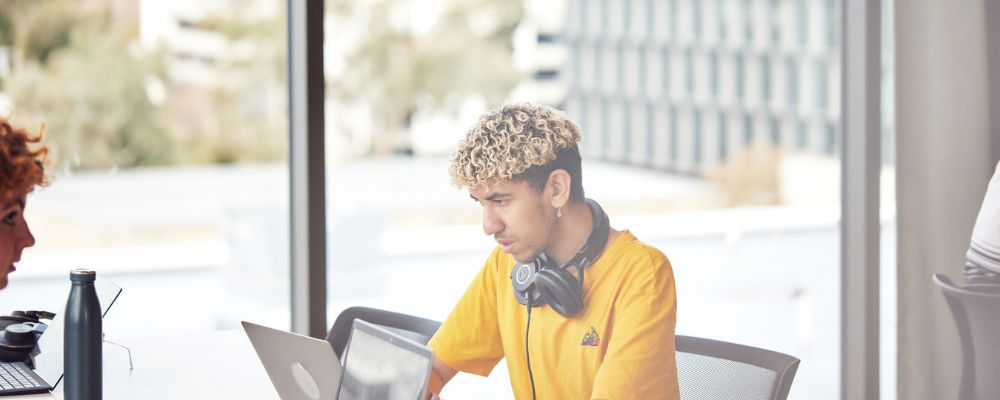 A male ANU studies at an upper level of a building at the Australian National University campus.